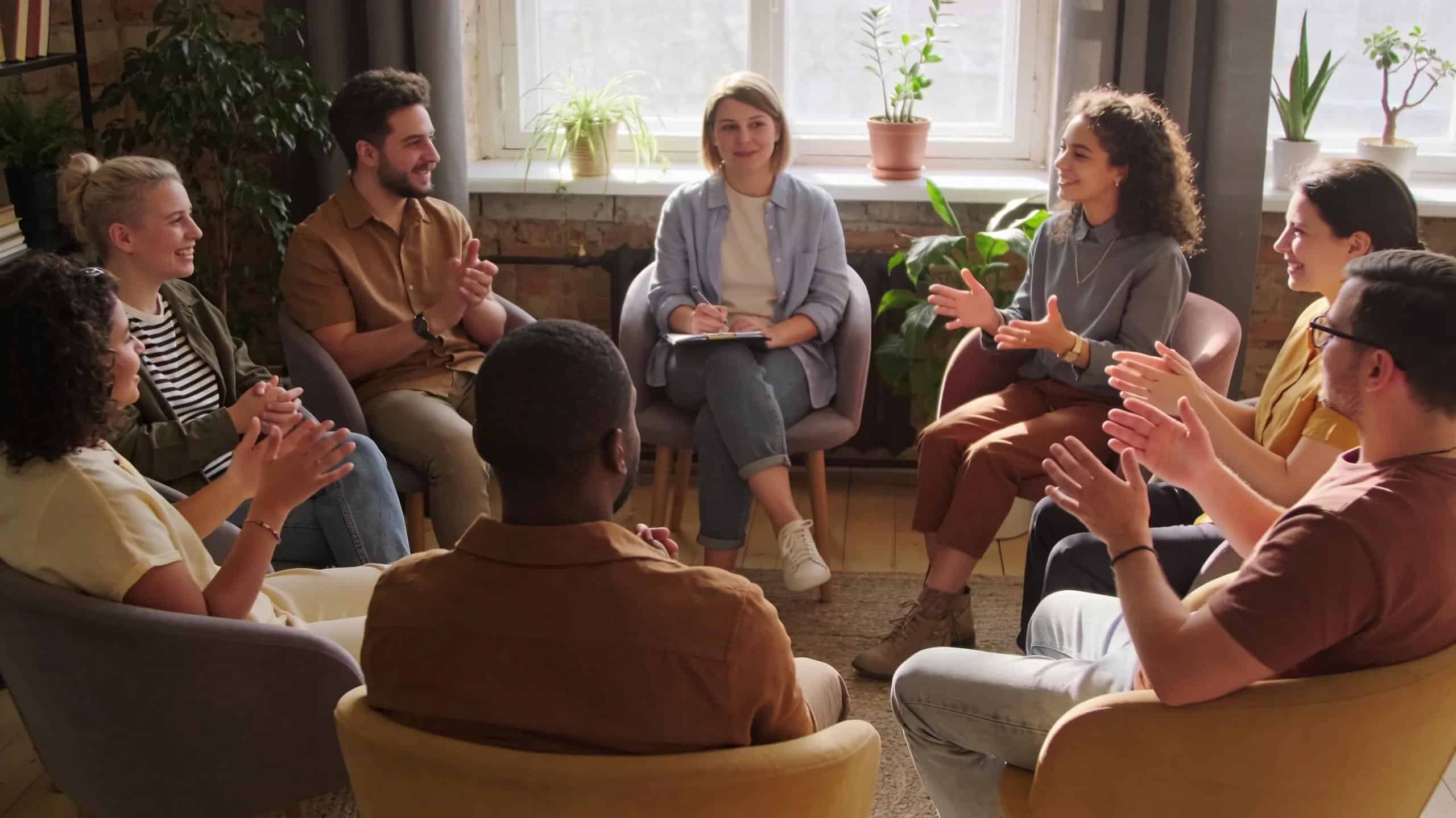 Participants in a group therapy session sharing experiences in a supportive environment