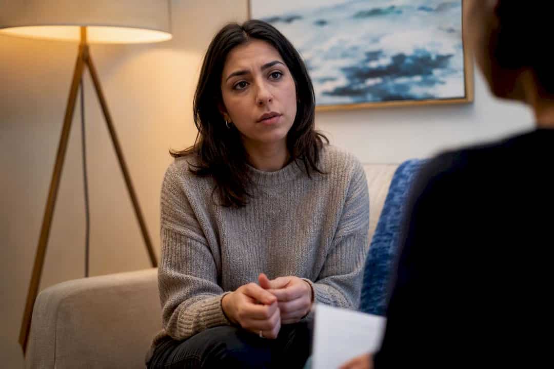 Therapy client pausing thoughtfully mid-session