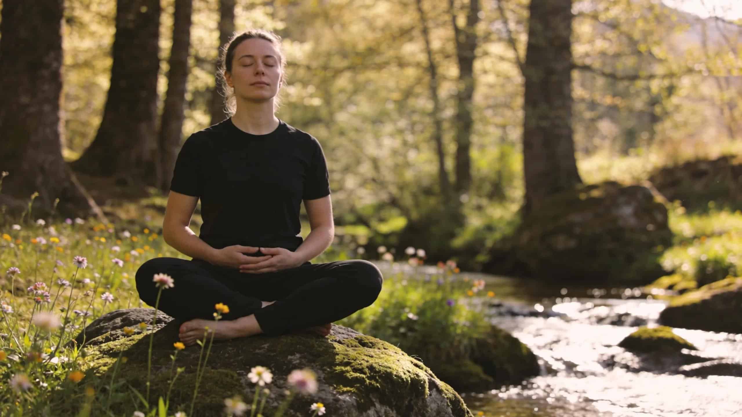 Person engaged in deep breathing exercises in nature, illustrating mindfulness and stress reduction techniques