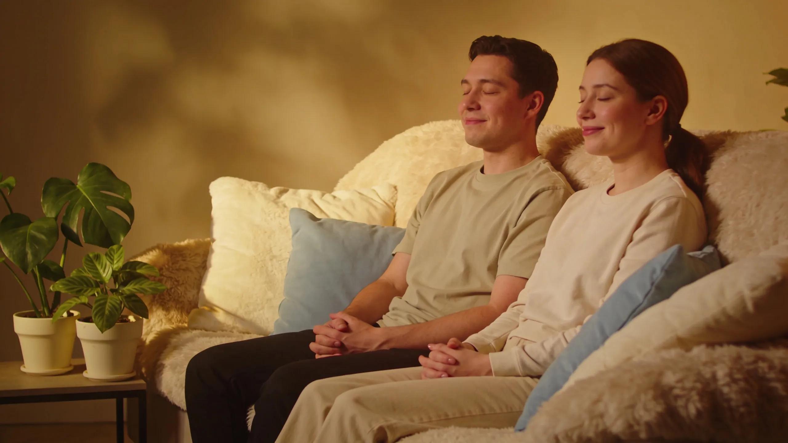 Couple engaging in mindfulness practice on a cozy couch, fostering emotional connection
