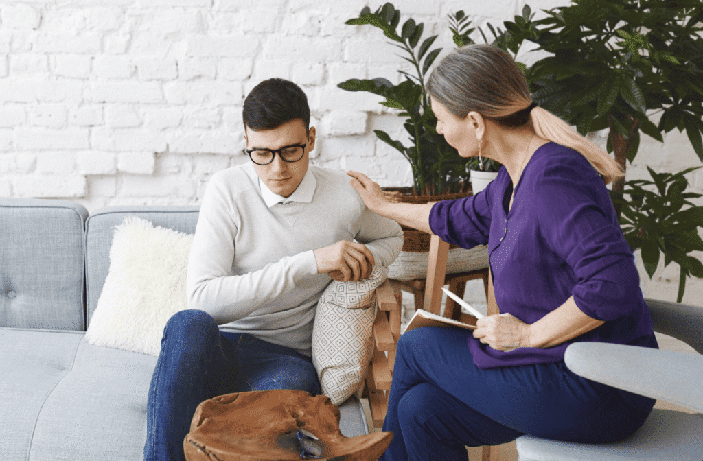 Therapist comforting an adult client on a couch during an adult therapy session in Paramus, New Jersey