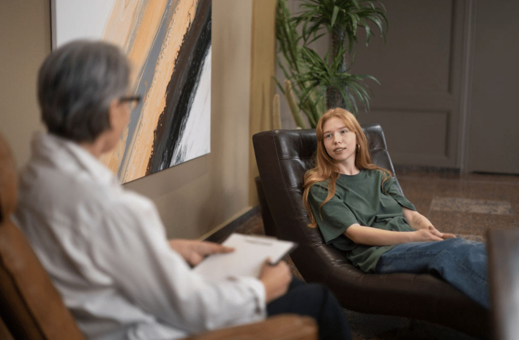 Young woman reclined in a leather chair talking with a therapist during an EMDR therapy session in Paramus, New Jersey