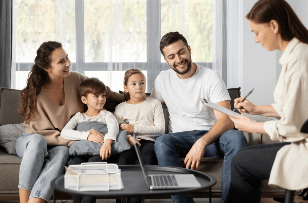Parents and two children sitting together on a couch with a therapist during family therapy in Paramus, New Jersey