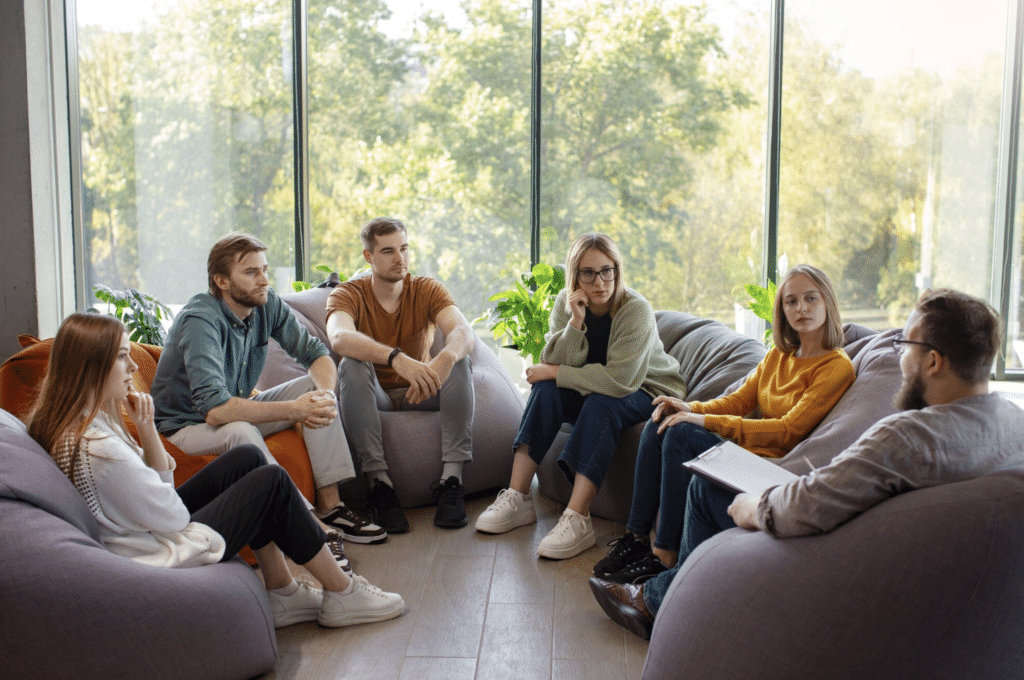 Therapist leading a group therapy session with adults seated in a circle in Paramus, New Jersey